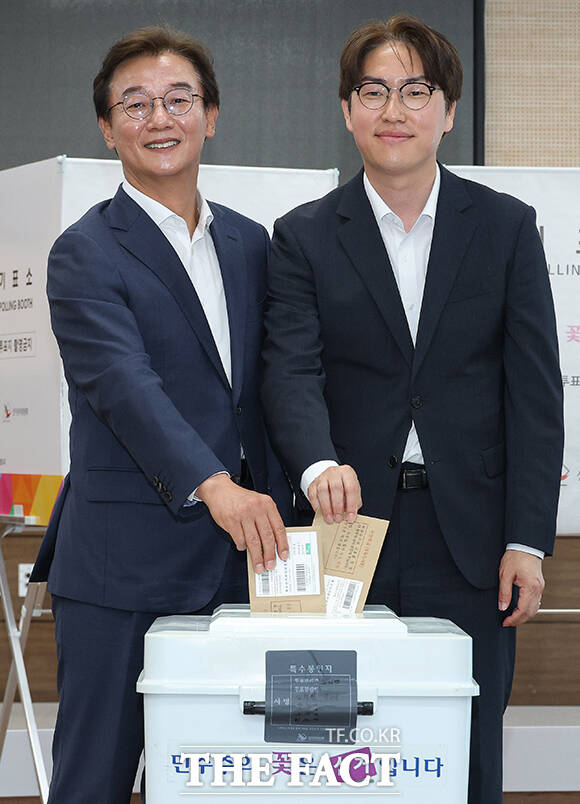 투표함에 사전투표 봉투 넣는 두 후보.