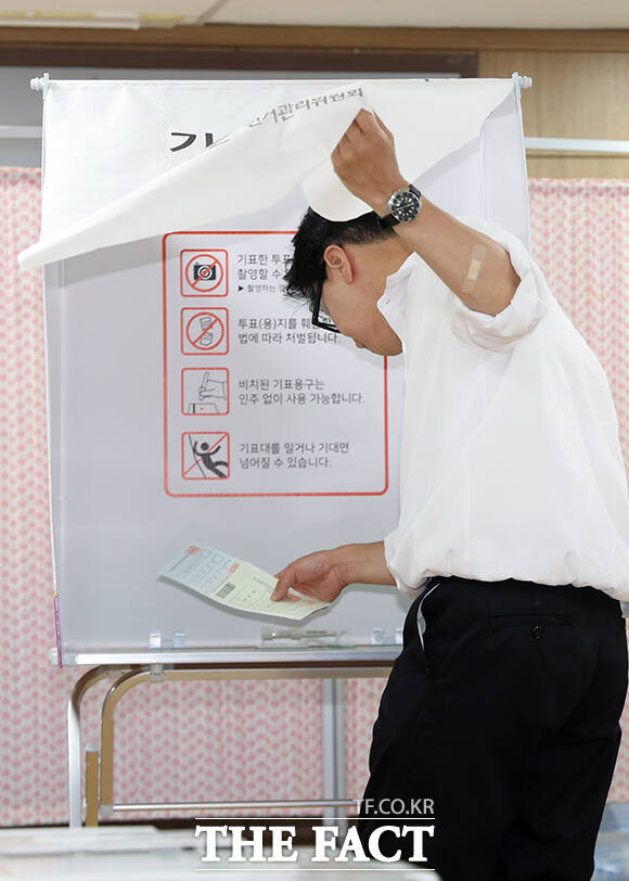 한 후보가 기표소로 들어가고 있다.