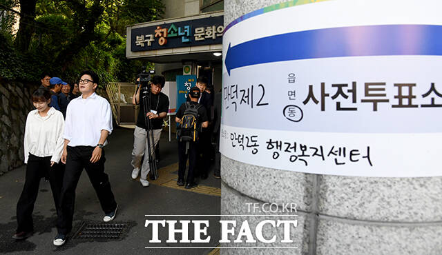 투표소 빠져나오는 한 후보(오른쪽)와 진 변호사.