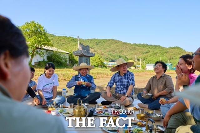 이재명 대통령이 15일 대구 군위군 소보면 도산1리 우무실마을을 찾아 모내기 작업을 하며 주민들과 새참을 함께하고 있다. /청와대