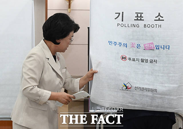 김부겸 더불어민주당 대구시장 후보의 부인 이유미 여사가 제9회 전국동시지방선거 사전투표 날인 29일 오전 대구 수성구 고산2동 행정복지센터에 마련된 사전투표소에서 김부겸 후보의 기표소를 열어보고 있다. /대구=박헌우 기자