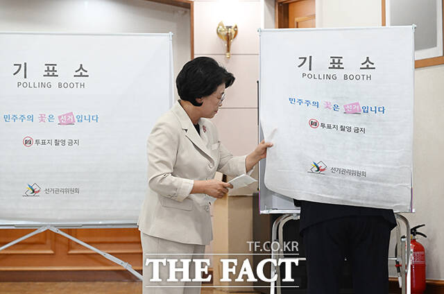 김부겸 더불어민주당 대구시장 후보의 부인 이유미 여사가 제9회 전국동시지방선거 사전투표 날인 29일 오전 대구 수성구 고산2동 행정복지센터에 마련된 사전투표소에서 김부겸 후보의 기표소를 열어보고 있다. /대구=박헌우 기자