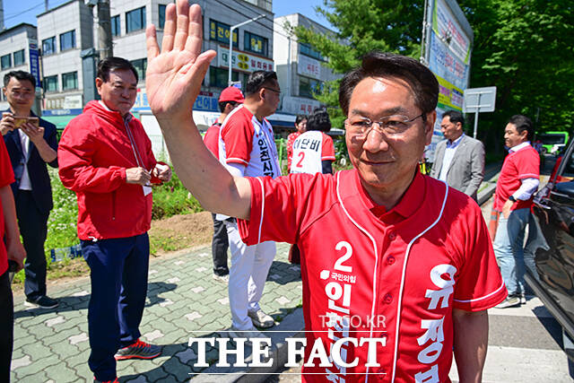 이날 삼산농산물시장을 방문한 유정복 후보가 지지자들을 향해 손인사 하는 모습.