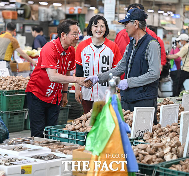이날 삼산농산물시장을 방문한 유정복 후보가 지지자들을 향해 손인사 하는 모습.