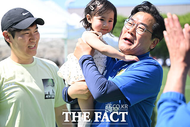 박찬대 더불어민주당 인천광역시장 후보(오른쪽)가 30일 오후 인천 부평구 한국GM 부평공장에서 열린 '한국GM 노조 55주년 체육대회'를 방문해 기념촬영을 위해 한 아이를 안고 있다. /인천=남윤호 기자