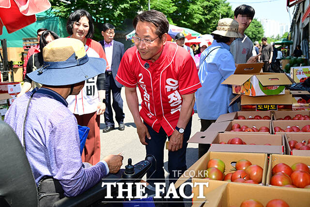 이날 삼산농산물시장을 방문한 유정복 후보가 지지자들을 향해 손인사 하는 모습.