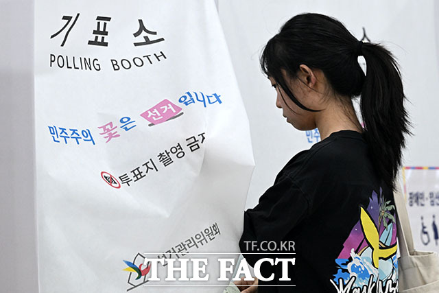 제9회 전국동시지방선거 사전투표 둘째 날인 30일 오후 서울 영등포구 신길4동주민센터에 마련된 사전투표소에서 유권자가 투표 용지를 받고 있다. /서예원 기자