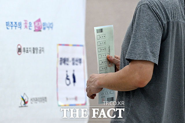 제9회 전국동시지방선거 사전투표 둘째 날인 30일 오후 서울 영등포구 신길4동주민센터에 마련된 사전투표소에서 유권자가 투표 용지를 받고 있다. /서예원 기자