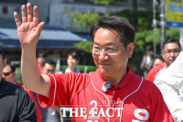 이날 삼산농산물시장을 방문한 유정복 후보가 지지자들을 향해 손인사 하는 모습.