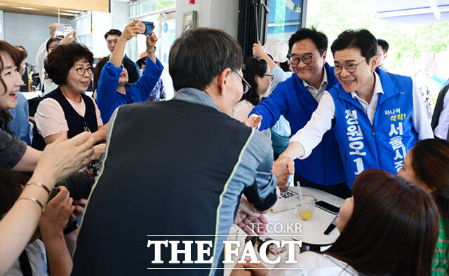 정원오 더불어민주당 서울시장 후보(왼쪽)와 전날 국회의장 임기를 마친 우원식 의원이 6·3 지방선거 전 마지막 주말이자 사전투표 둘째날인 30일 서울 노원구 경춘선숲길에서 시민들을 만나 인사하고 있다. /이새롬 기자