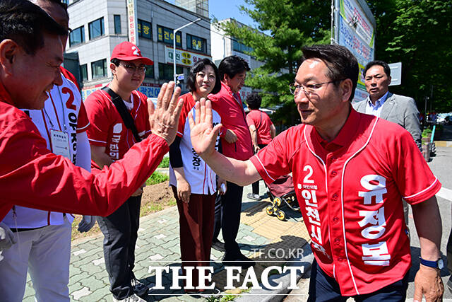 이날 삼산농산물시장을 방문한 유정복 후보가 지지자들을 향해 손인사 하는 모습.