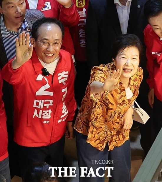 박근혜 전 대통령이 지난 23일 추경호 국민의힘 대구시장 후보와 함께 대구시 북구 칠성시장을 찾아 시민들에게 손을 흔들고 있다. /뉴시스