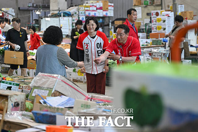 이날 삼산농산물시장을 방문한 유정복 후보가 지지자들을 향해 손인사 하는 모습.