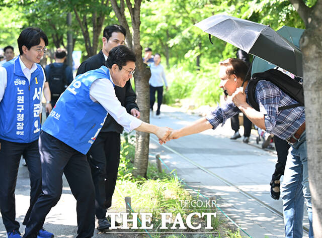 정원오 더불어민주당 서울시장 후보(왼쪽)와 전날 국회의장 임기를 마친 우원식 의원이 6·3 지방선거 전 마지막 주말이자 사전투표 둘째날인 30일 서울 노원구 경춘선숲길에서 시민들을 만나 인사하고 있다. /이새롬 기자