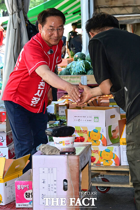 이날 삼산농산물시장을 방문한 유정복 후보가 지지자들을 향해 손인사 하는 모습.