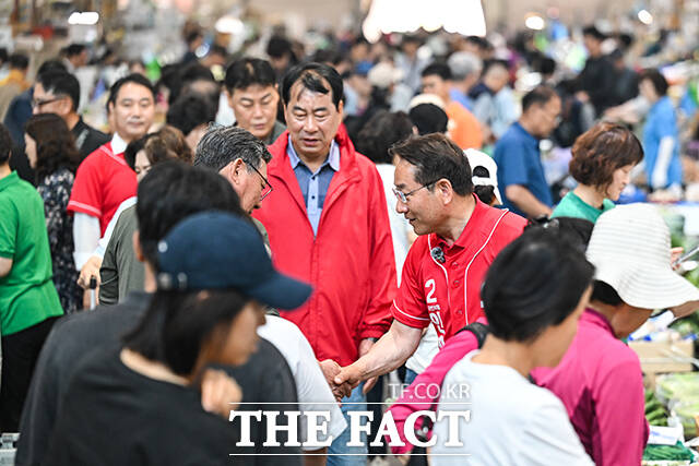 이날 삼산농산물시장을 방문한 유정복 후보가 지지자들을 향해 손인사 하는 모습.