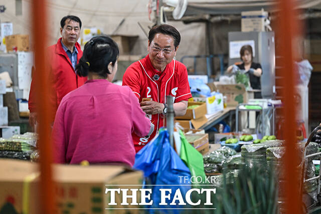 이날 삼산농산물시장을 방문한 유정복 후보가 지지자들을 향해 손인사 하는 모습.