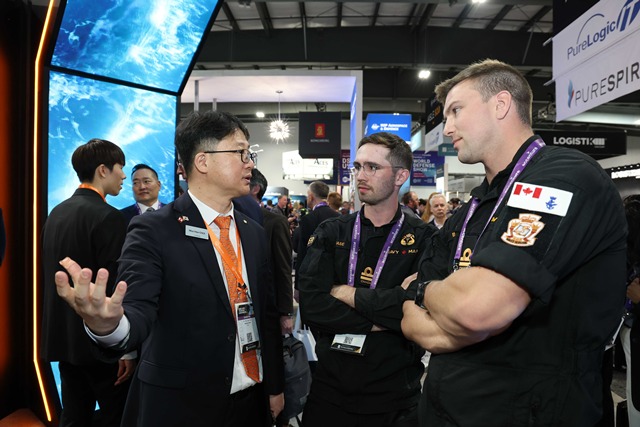 캐나다 오타와에서 열린 'CANSEC 2026' 전시회 내 한화오션 부스에서, 한화오션 관계자가 방문객들에게 최신예 잠수함인 KSS-III 모델을 소개하며 그 우수성을 설명하고 있다. /한화오션