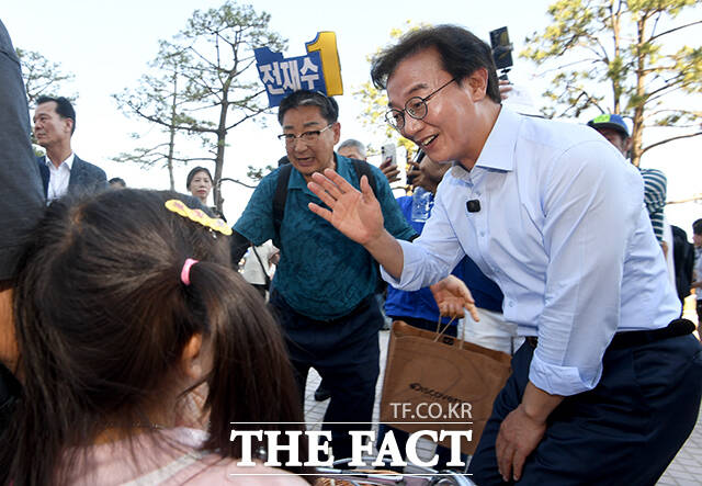 어린이들과 인사하는 전 후보.