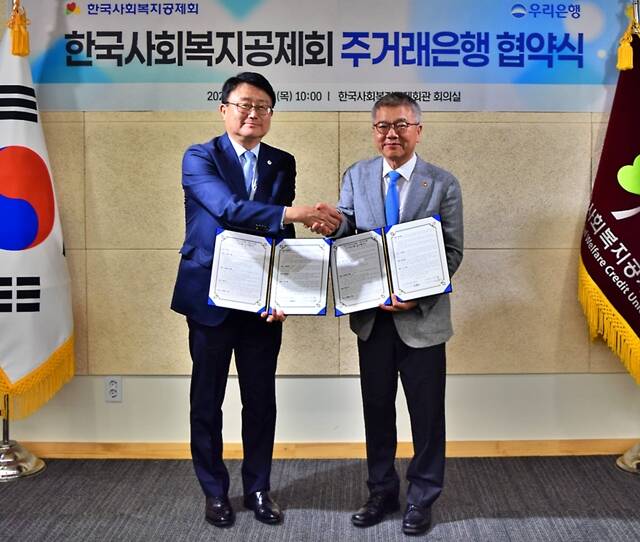 4일 한국사회복지공제회관에서 열린 '주거래은행 협약식'에 참석한 조세형 우리은행 기관그룹장(왼쪽)과 김용하 한국사회복지공제회 이사장이 기념 촬영을 하고 있다. /우리은행