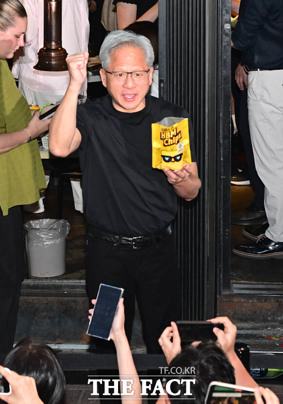 젠슨 황 엔비디아 최고경영자(CEO)가 5일 서울 마포구 서교동의 한 고깃집에서 최태원 SK회장, 구광모 LG회장, 이해진 네이버 의장과 삼겹살 회동을 하는 도중 시민들에게 SK에서 만든 ‘HBM’칩스를 전달하고 있다. /이새롬 기자