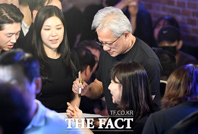 서명 요청에 응하는 황 CEO.