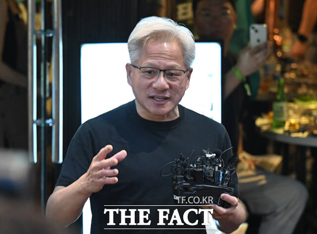 젠슨 황 엔비디아 최고경영자(CEO)가 5일 서울 마포구 서교동의 한 고깃집에서 최태원 SK회장, 구광모 LG회장, 이해진 네이버 의장과 삼겹살 회동을 하는 도중 시민들에게 SK에서 만든 ‘HBM’칩스를 전달하고 있다. /이새롬 기자