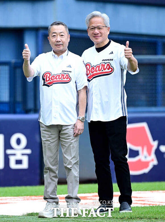 젠슨 황 엔비디아 최고경영자(CEO)가 7일 잠실야구장에서 열린 KBO리그 두산과 키움의 경기에서 시구를 마친 뒤 구단주 박정원 두산그룹 회장과 포옹하고 있다. /사진공동취재단
