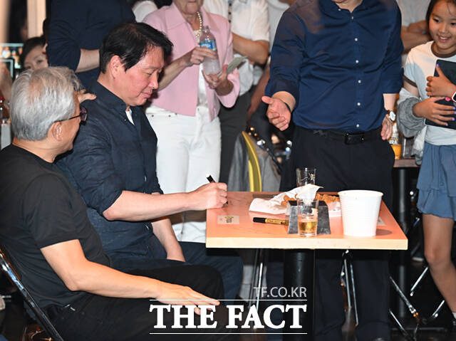 최태원 SK그룹 회장이 7일 서울 강남구 삼성동 치킨 전문점 ‘깐부치킨’에서 지난해 황 CEO가 이재용 삼성전자 회장과 정의선 현대차그룹 회장과 함께 자리했던 테이블에 착석해 사인하고 있다.