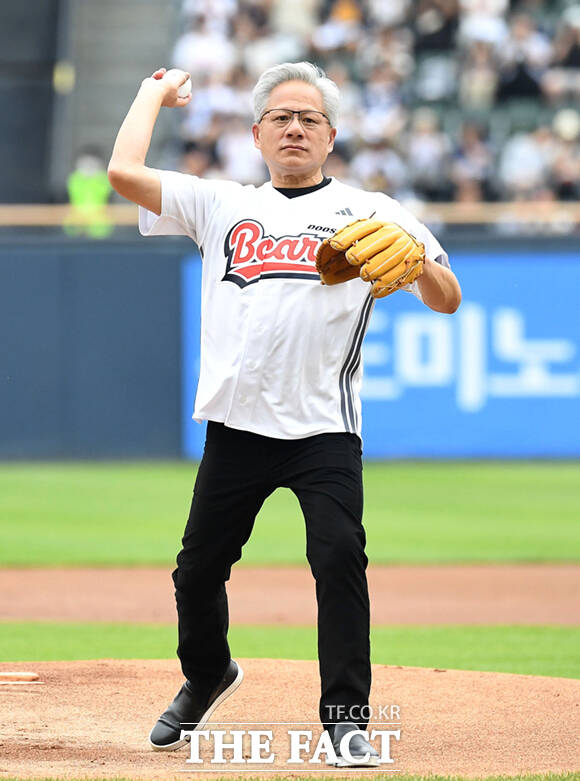 젠슨 황 엔비디아 최고경영자(CEO)가 7일 잠실야구장에서 열린 KBO리그 두산과 키움의 경기에서 시구를 마친 뒤 구단주 박정원 두산그룹 회장과 포옹하고 있다. /사진공동취재단