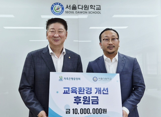 오화경 저축은행중앙회장(왼쪽)과 공의석 서울다원학교 교장이 후원금 전달식에서 기념촬영을 하고 있다. /저축은행중앙회