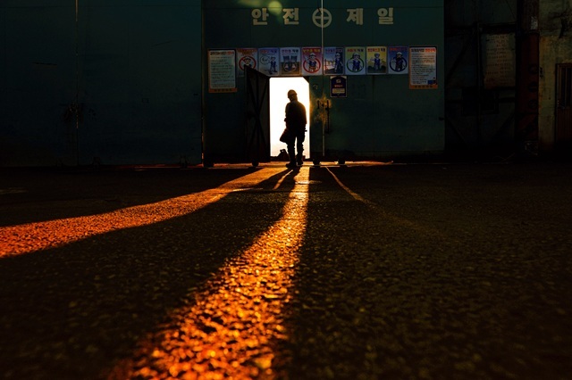 노을빛이 길게 드리운 산업현장에서 잠시 휴식을 마치고 다시 일터로 향하는 선박 수리공의 뒷모습을 담은 정철재 씨의 일터로가 제9회 더팩트 사진 공모전 <사진이 더팩트다>에서 대상의 영예를 차지했다. 대상 수상작 정철재 씨의 일터로.