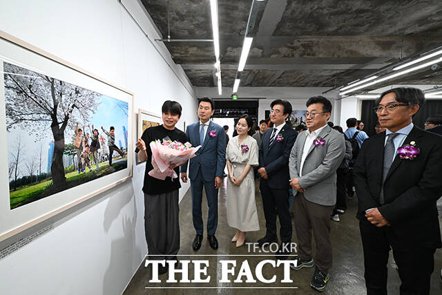 보건복지부 장관상을 수상한 노희완 씨의 작품 '한국에서 낳았어요'를 대리수상자인 아들 노경남 씨(왼쪽)가 참석 내빈들에게 설명하고 있다. 왼쪽 두 번째부터 김상규 더팩트 대표이사, 이주영 개혁신당 의원, 김성회 더불어민주당 의원, 박종현 한국기자협회장, 김기정 한국인터넷신문협회장. /남윤호 기자