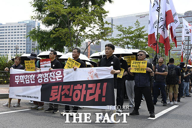 노조원들이 손팻말을 들고 있다.
