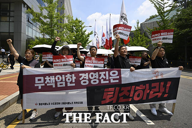 노조원들이 손팻말을 들고 있다.