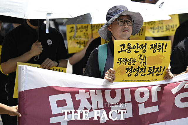 노조원들이 손팻말을 들고 있다.