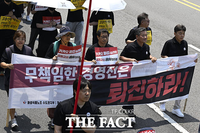 노조원들이 손팻말을 들고 있다.