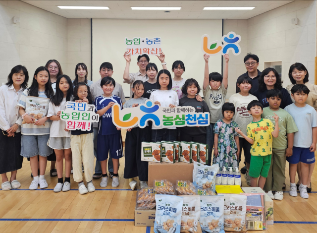 기부물품 전달식에 참석한 학생들과 주요 관계자들이 기념촬영을 하고 있다. /NH농협카드
