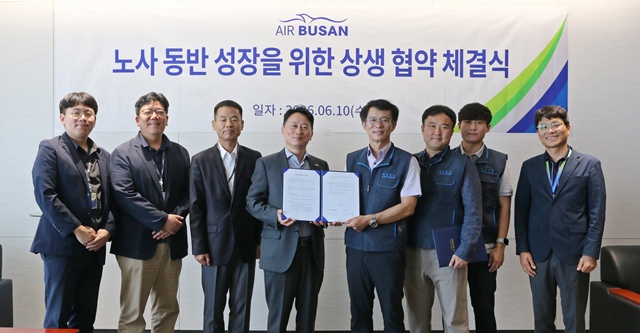 정병섭 에어부산 대표이사(왼쪽에서 네 번째)와 남이훈 에어부산 조종사노동조합 위원장(다섯 번째)을 비롯한 노사 관계자들이 지난 10일 자사 사옥에서 상생 협약을 체결한 후 기념촬영을 하고 있다. /에어부산