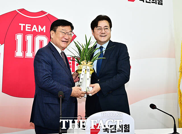 홍익표 청와대 정무수석이 11일 오후 서울 여의도 국회에서 정점식 국민의힘 신임 원내대표(왼쪽)를 예방하며 이재명 대통령이 보낸 축하난을 전달하고 있다. /국회=배정한 기자