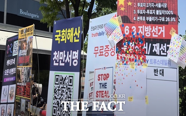 서울지하철 5호선과 9호선이 다니는 올림픽공원역 출구 앞에는 태극기와 성조기를 판매하는 상인들이 여전히 자리를 지키고 있었고, 한쪽에는 부정선거 의혹에 동의하냐고 묻는 스티커 투표판과 관련 영화를 상영하는 플랫폼 홍보 플래카드가 크게 걸려 있었다. /서울 올림픽공원=오승혁 기자