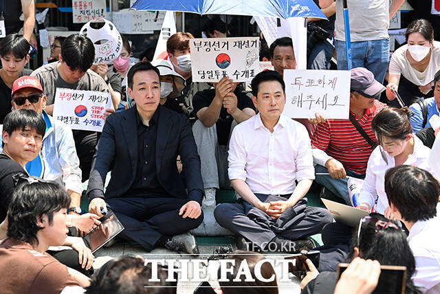 6·3 전국동시지방선거 '투표용지 부족 사태'로 잠실 개표소 봉쇄 시위가 이어지고 있는 16일 오후 장동혁 국민의힘 대표가 서울 송파구 올림픽공원 핸드볼경기장 개표소 앞에 앉아 있다. /박헌우 기자