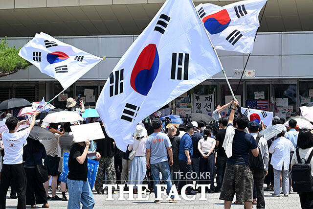 6·3 지방선거 ‘투표용지 부족 사태’로 12일째 잠실 개표소 봉쇄 시위가 이어지고 있는 16일 오후 서울 송파구 올림픽공원 핸드볼경기장 앞에서 시위대가 애국가를 부르고 있다. /서예원 기자