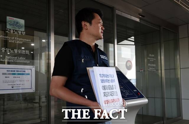 지난달 18일 사후조정 회의가 열리는 정부세종청사 중앙노동위원회 입구에서 삼성노조 DX부문 노조원들이 'DX 차별금지'를 주장하고 있다. /뉴시스
