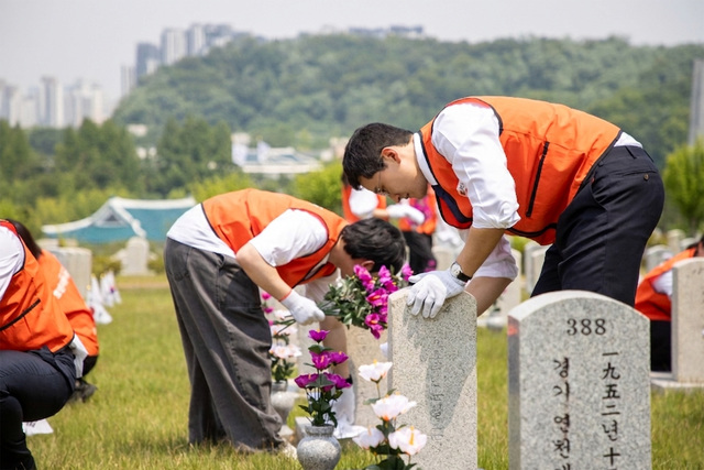 호반그룹은 지난 18일 서울 동작구 국립서울현충원에서 묘역 정화 봉사활동을 펼쳤다. 사진은 김대헌 호반그룹 기획총괄사장(오른쪽)이 국립서울현충원에서 그룹 신입사원들과 함께 묘역 정화 봉사활동을 하고 있는 모습. /호반그룹