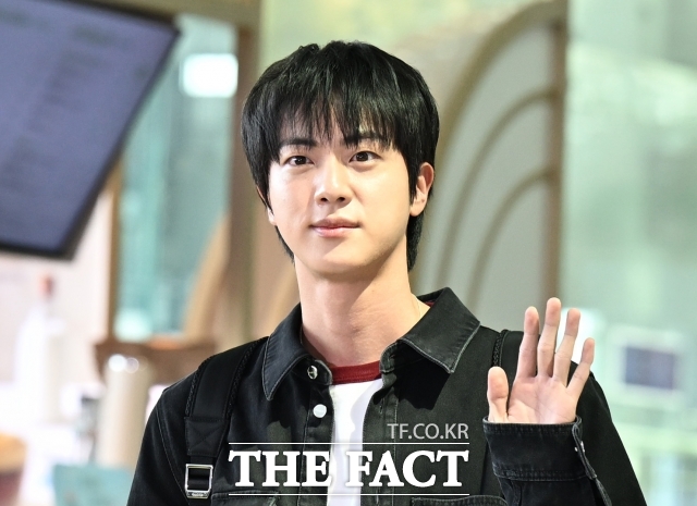 BTS 멤버 김석진 진의 전역 기념 행사에서 벌어진 이른바 '기습 입맞춤' 사건이 오는 7월 재판에 들어가면서 다시 큰 논란이 되고 있다. 사진은 진이 해외 일정 참석을 위해 인천국제공항 제2여객터미널 출국장에 도착해 손을 흔들고 있다. /더팩트 DB