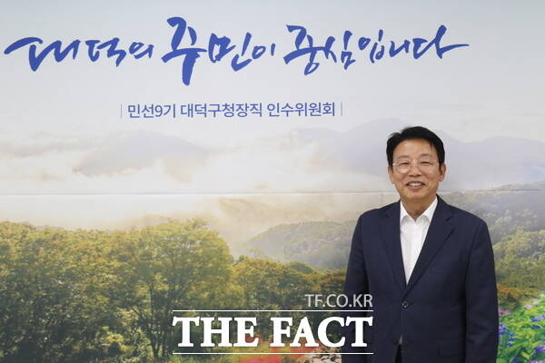 김찬술 대전시 대덕구청장 당선인이 지난 19일 <더팩트>와 인터뷰를 진행한 후 인수위원회 슬로건이 적힌 배경 앞에서 기념 촬영을 하고 있는 모습. /정예준 기자