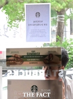  불꺼진 스타벅스 매장 살펴보는 고객 [포토]