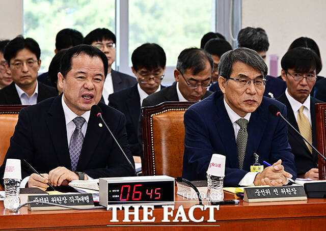 질의에 답변하는 위철환 중앙선관위원장 직무대행(왼쪽).
