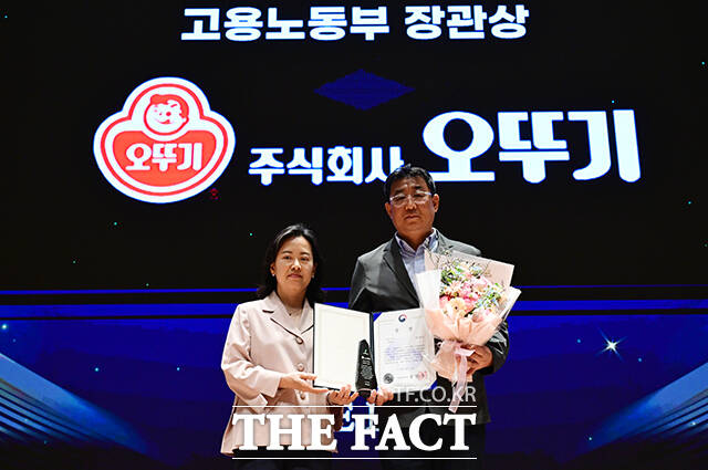 2026 더팩트 ESG 경영대상 시상식이 23일 오후 서울 여의도 한국거래소 컨퍼런스홀에서 열린 가운데 홍경의 고용노동부 대변인이 이유신 오뚜기 상무에게 고용노동부 장관상을 수여한 뒤 기념사진을 찍고 있다. /임영무 기자